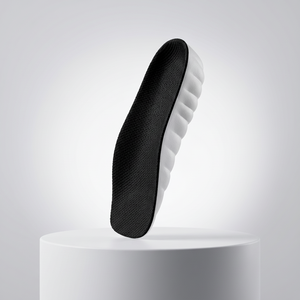 ASCEND height insole standing upright on a white pedestal, front view of the black mesh surface
